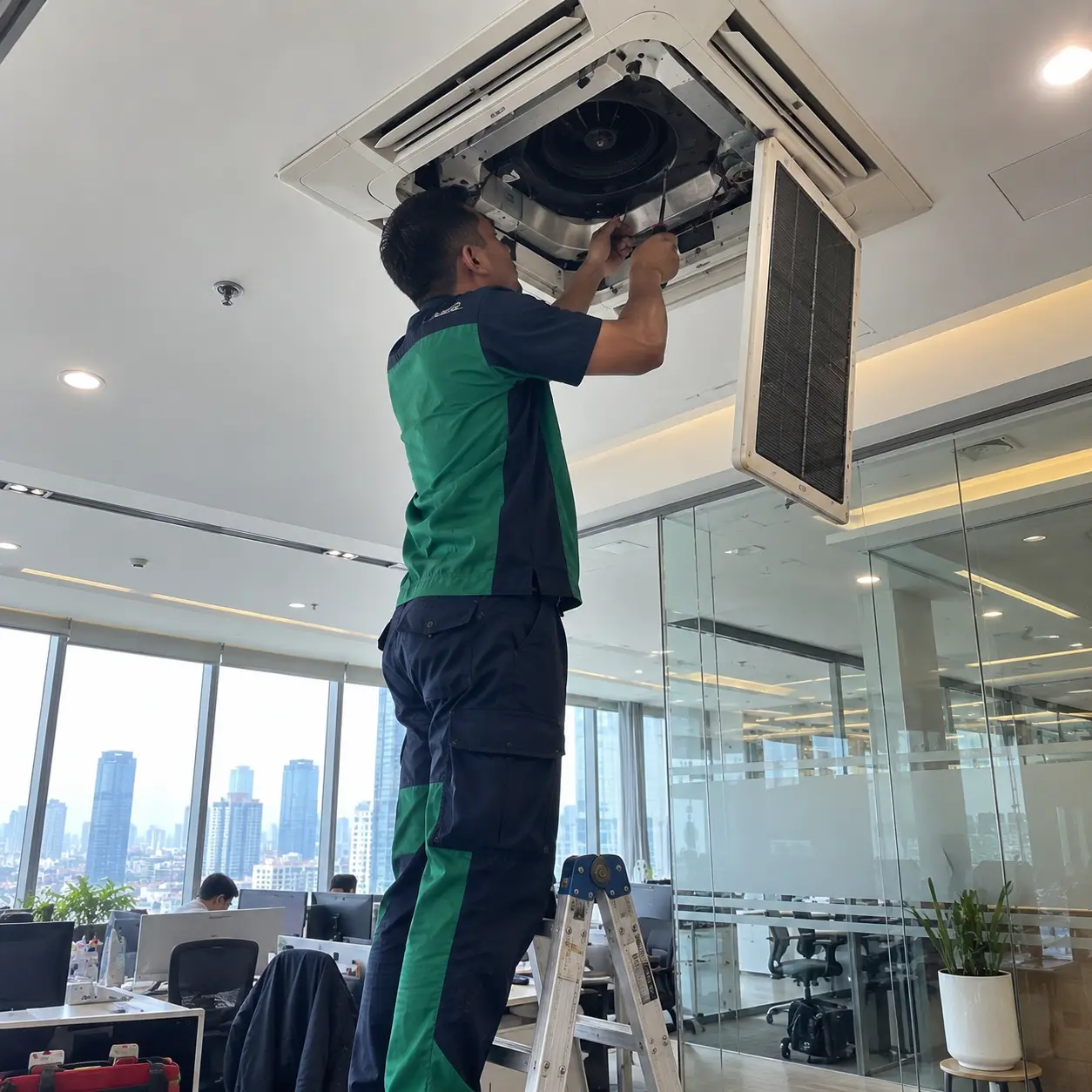 Teknisi bekerja pada sistem AC di gedung